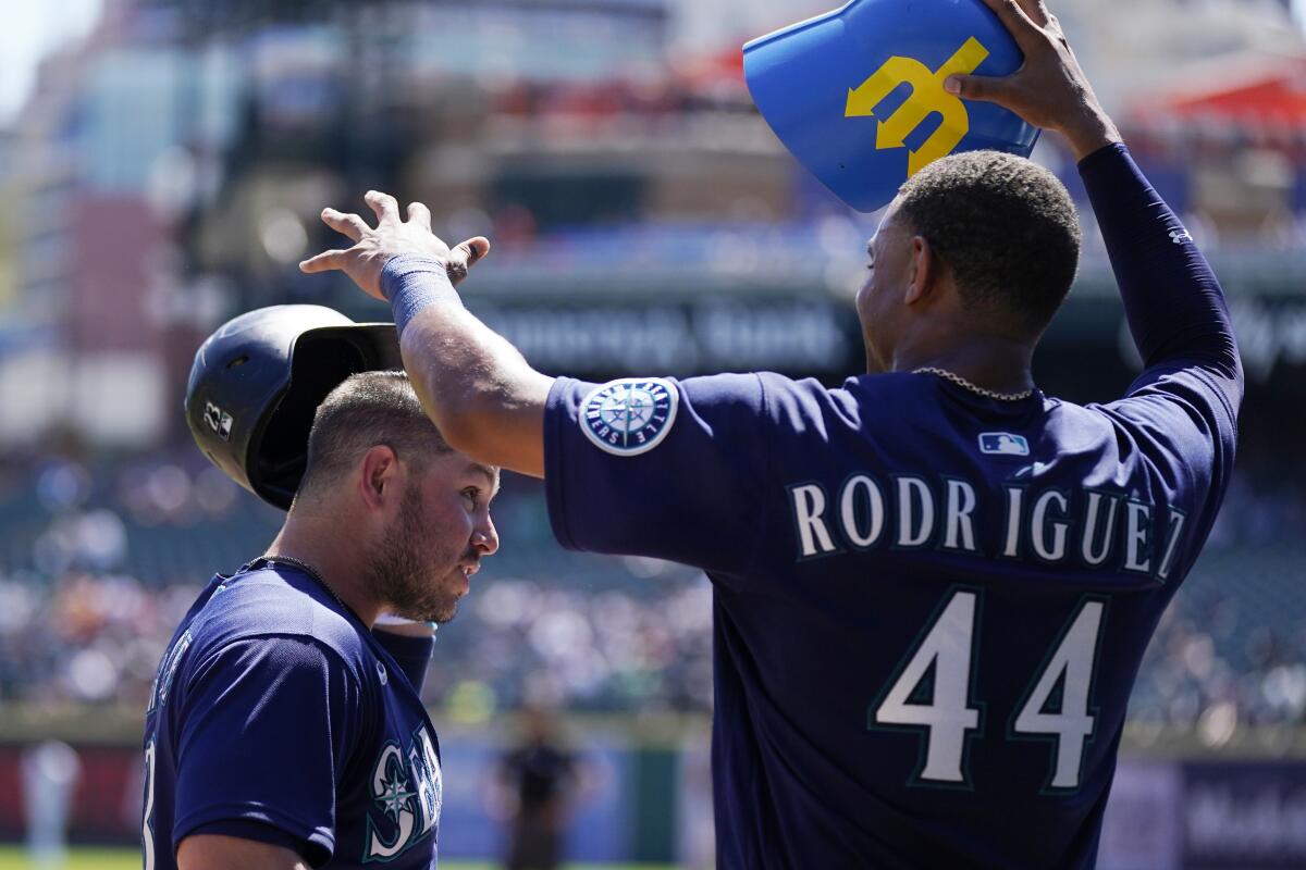 Seattle Mariners' Julio Rodriguez puts the home run helmet on Ty France after a solo home run during the third inning of a baseball game against the Detroit Tigers, Thursday, Sept. 1, 2022, in Detroit. (AP Photo/Carlos Osorio)