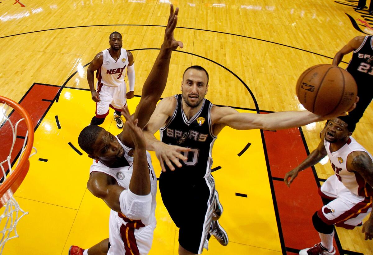 San Antonio Spurs' Manu Ginobili goes up for a layup against Miami Heat's Chris Bosh.