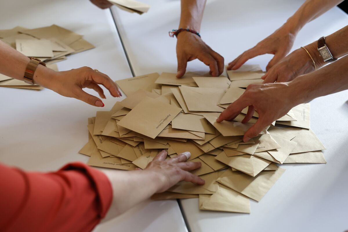Volunteers count ballots at a polling station 