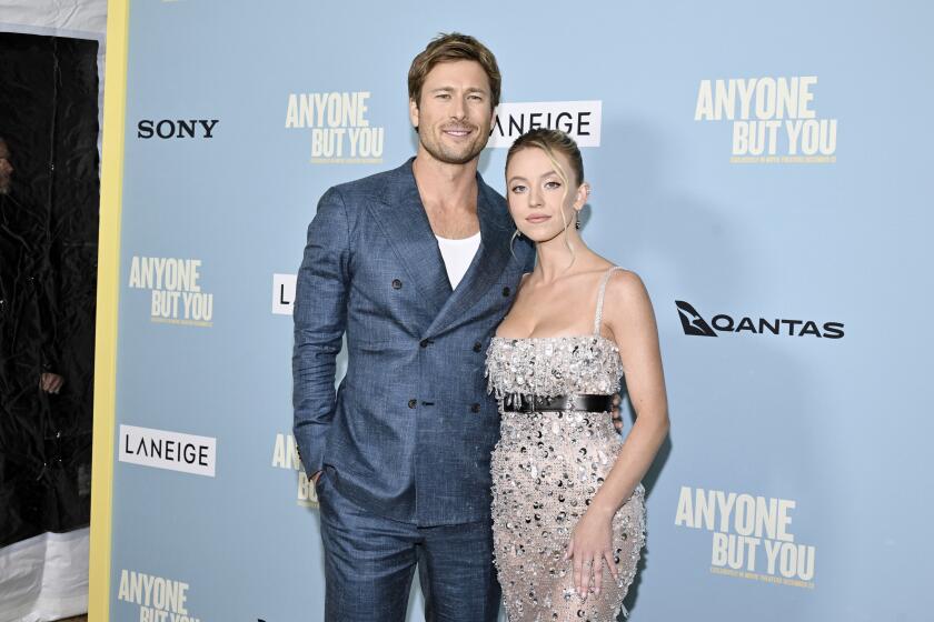 Actors Glen Powell, left, and Sydney Sweeney right embrace at the premiere of their film 