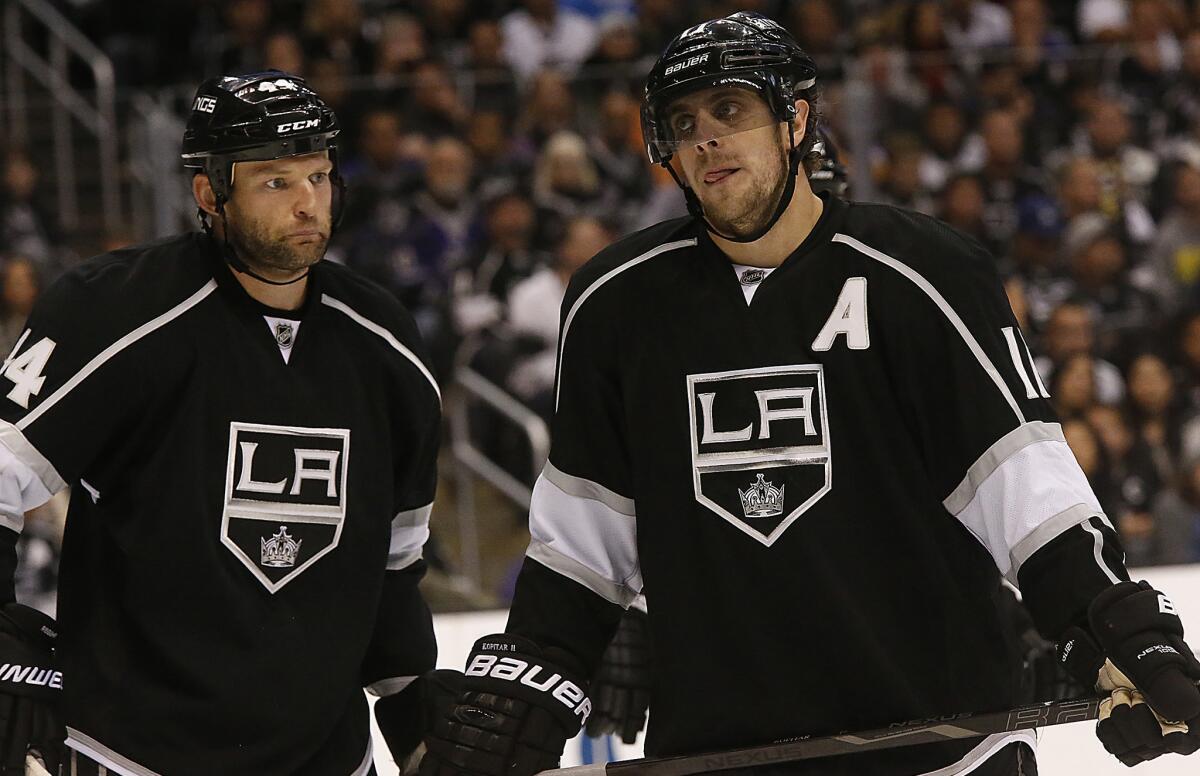 Kings teammates Robyn Regehr, left, and Anze Kopitar line up for a faceoff during the Kings' 4-3 overtime loss to the San Jose Sharks on Tuesday. The Kings' season will be on the line Thursday in Game 4 of the Western Conference quarterfinals.