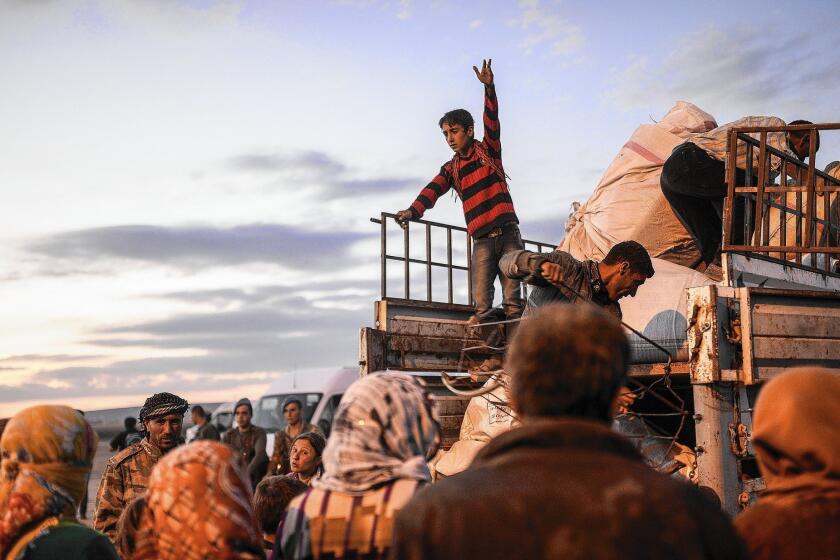 Syrian Kurds load their belongings in the southeastern Turkish town of Suruc after fleeing an onslaught by Islamic State militants in northern Syria.