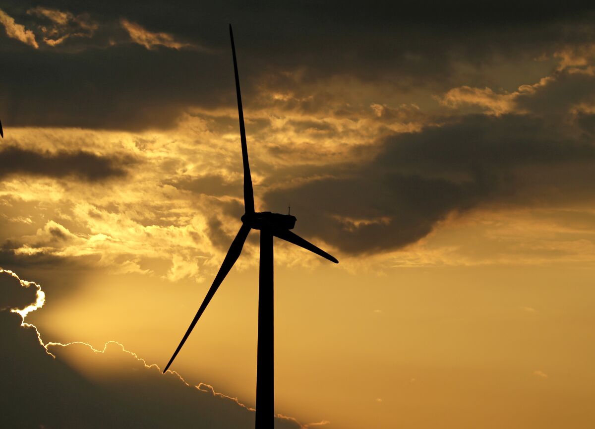 A wind turbine is silhouetted against the setting sun near King City, Mo. 