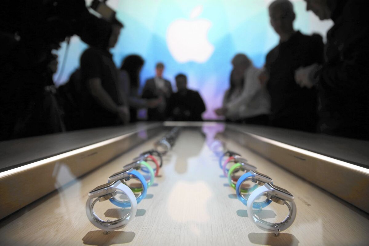People in Germany look at a selection of Apple Watches after the Apple Watch announcement in San Francisco was broadcast on a screen in the Apple Store in Berlin.