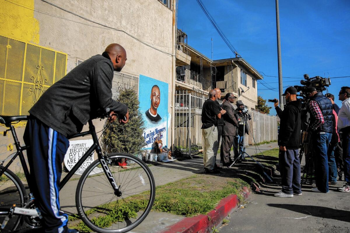 Edsell Ford, left, the father of Ezell Ford, listens to a news conference with Los Angeles civil rights leaders at the corner of 65th Street and Broadway in South Los Angeles, where his son was killed.