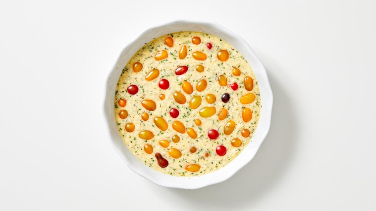 Minced soft herbs and two cheeses flavor the custard for this savory clafoutis, dotted with tiny cherry tomatoes.