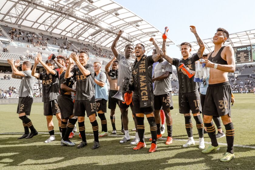 Cristian Arango, third from the right wearing a man of the match scarf, and his LAFC teammates celebrate after defeating the San Jose Earthquakes on Saturday, Oct. 16, at Banc of California Stadium in Los Angeles.