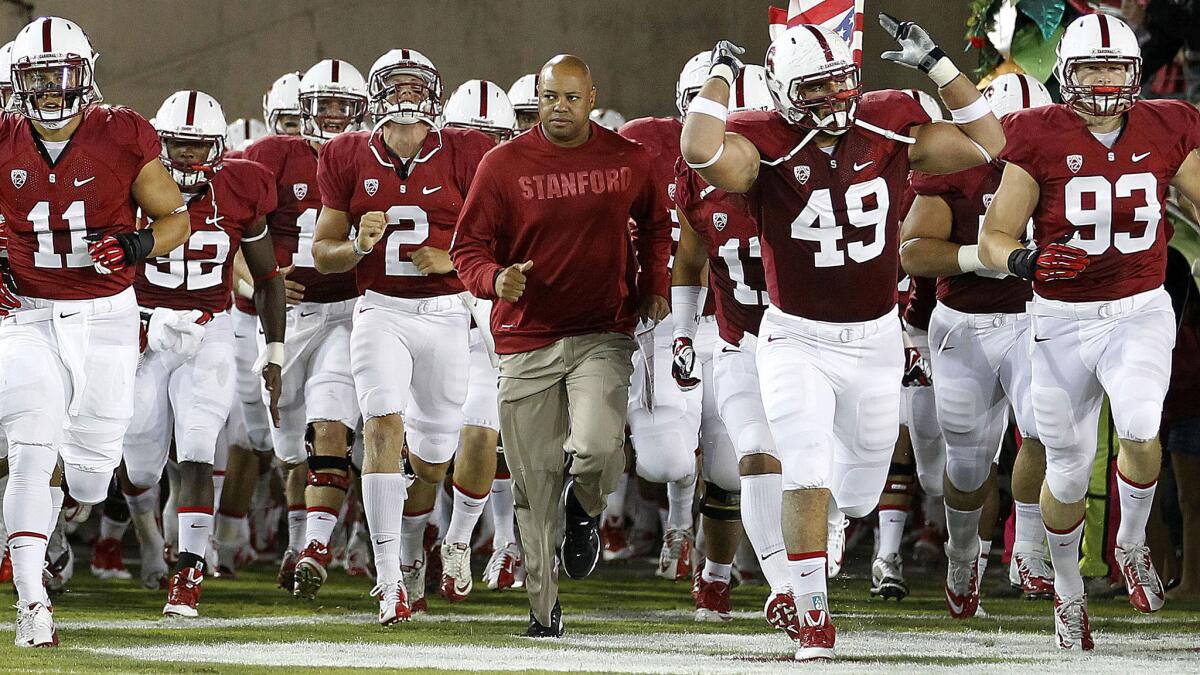 Stanford Coach David Shaw, center, runs onto the field with his players before a 2013 game against San Jose State. Will the Cardinal remain among the elite teams in the Pac-12 this season?