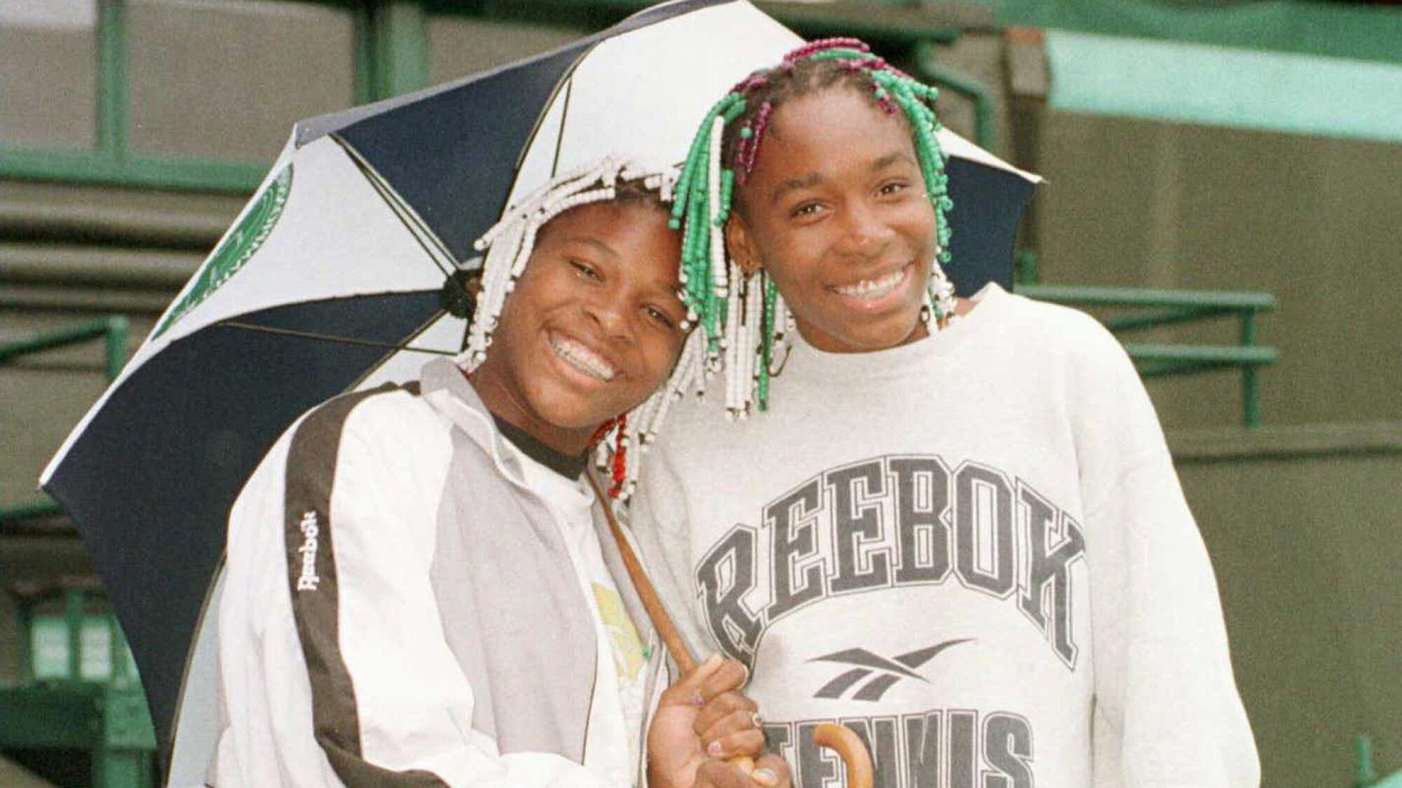 Sisters Serena, left, and Venus Williams wait out a rain delay at Wimbledon in 1997.