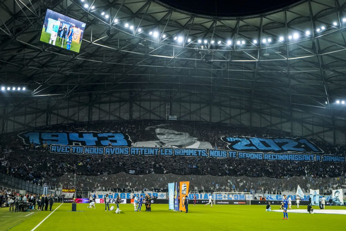 A giant image of the late Bernard Tapie is displayed prior of the French League One soccer match between Marseille and FC Lorient at the Velodrome stadium in Marseille, France, Sunday, Oct. 17, 2021. Bernard Tapie, a flamboyant businessman who was beloved by sports fans for leading French soccer club Marseille to glory but also dogged by legal battles and corruption investigations, has died. He was 78. (AP Photo/Daniel Cole)