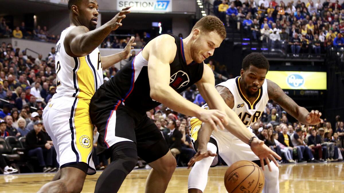Clippers forward Blake Griffin tries to get a grasp on the ball while facing the double-team defense of Pacers guards Rodney Stuckey, left, and Aaron Brooks during their game Sunday.