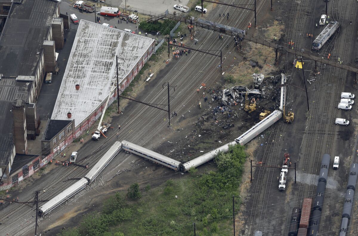 Aerial view of a derailed train with several cars on their sides