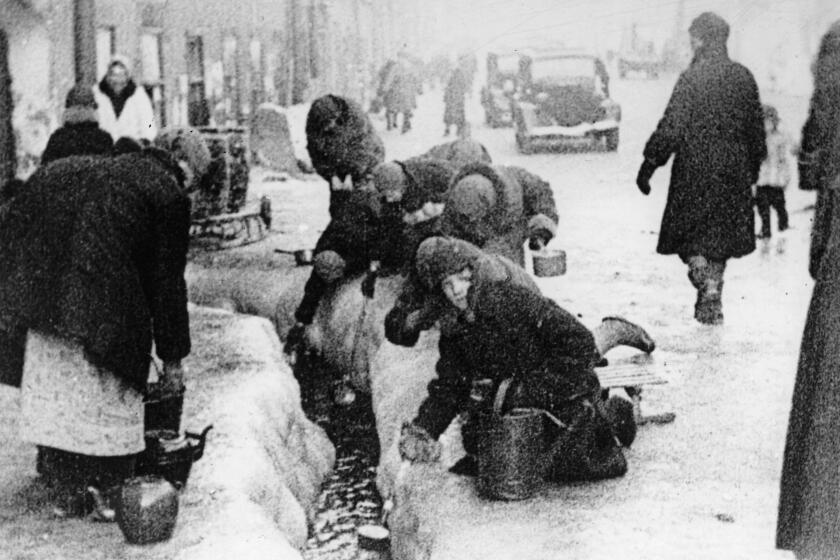 FILE - This file photo, taken in the winter months of 1942, shows citizens of Leningrad as they dig up water from a broken main, during the 900-day siege of the Russian city by German invaders.The Conference on Jewish Material Claims Against Germany that handles claims on behalf of Jews who suffered under the Nazis says the German government has agreed to extend compensation to Jewish survivors who endured the World War II siege of Leningrad and two other groups who had so far not received any monthly pensions. (AP Photo, File)