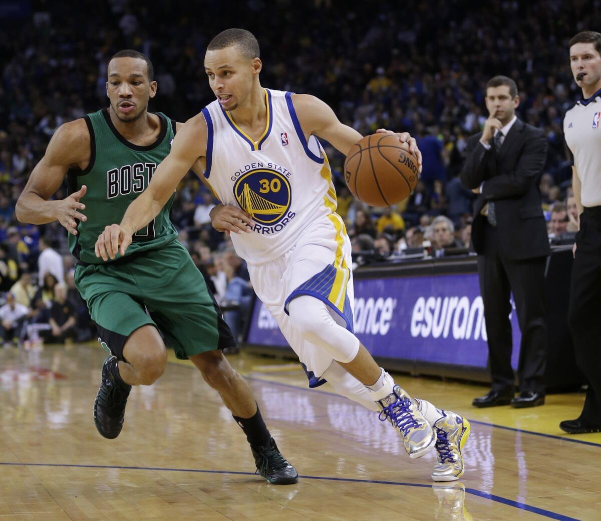 Stephen Curry dribbles past Avery Bradley during the second half of Golden State's 99-97 win Friday over the Boston Celtics.