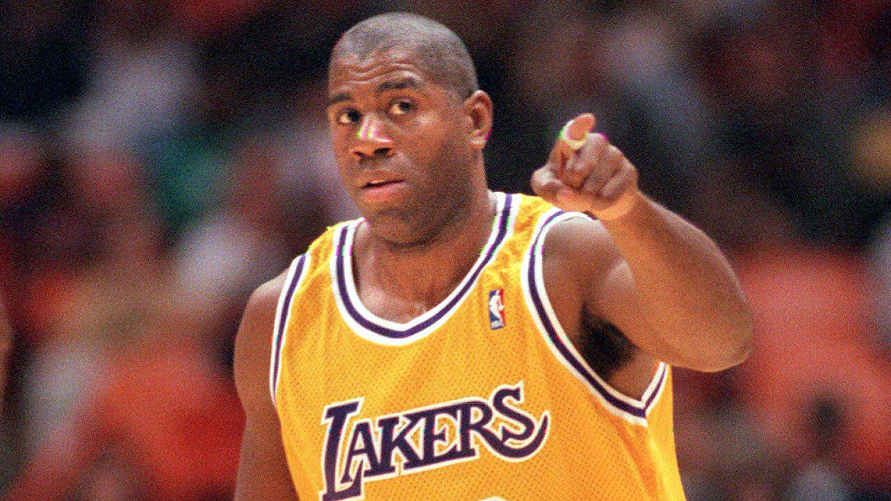 Lakers star Magic Johnson points to the bench after scoring during a game against the Houston Rockets in March 1996.