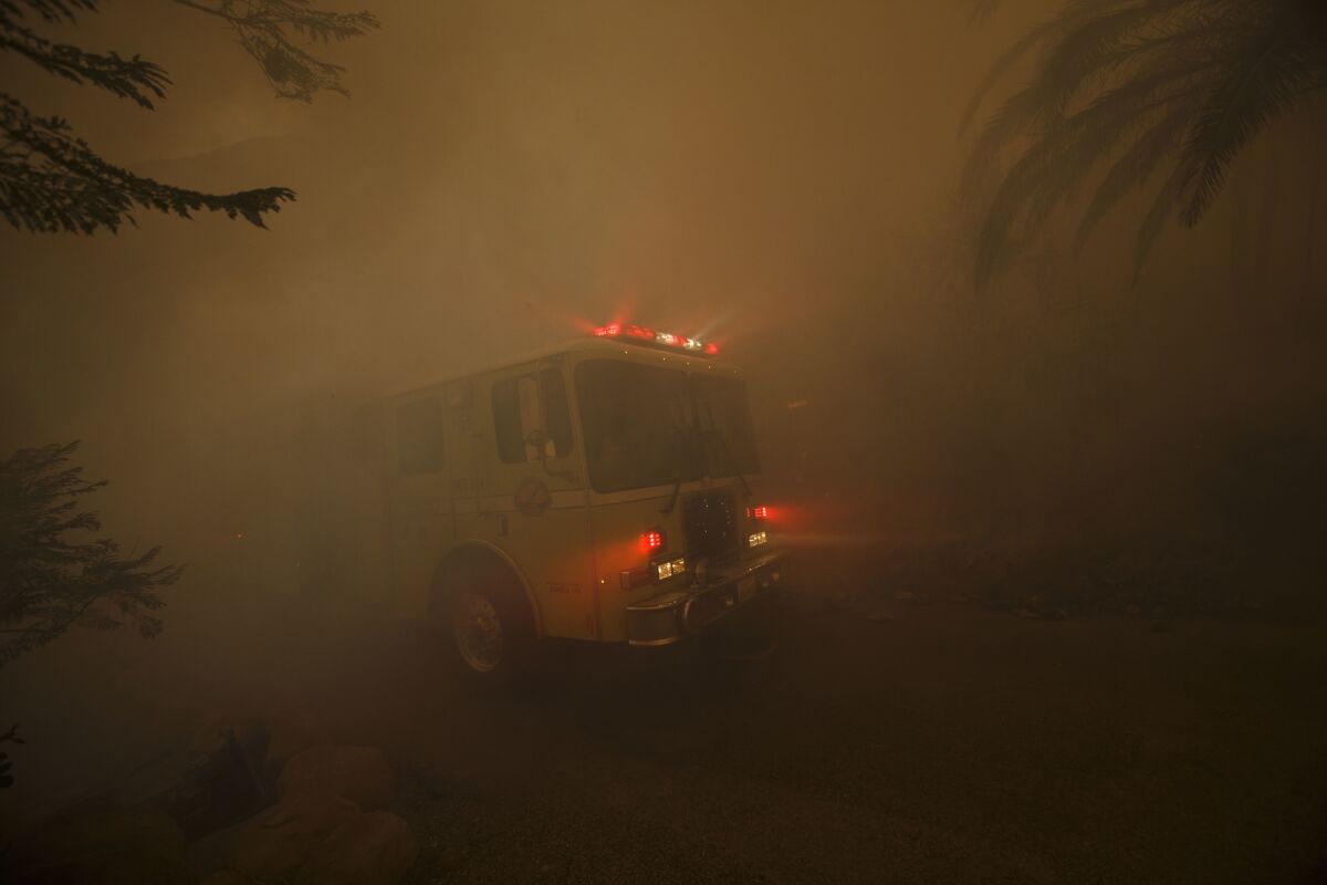 A fire truck pulls responds to fires burning near homes on East Mountain Drive in Montecito.