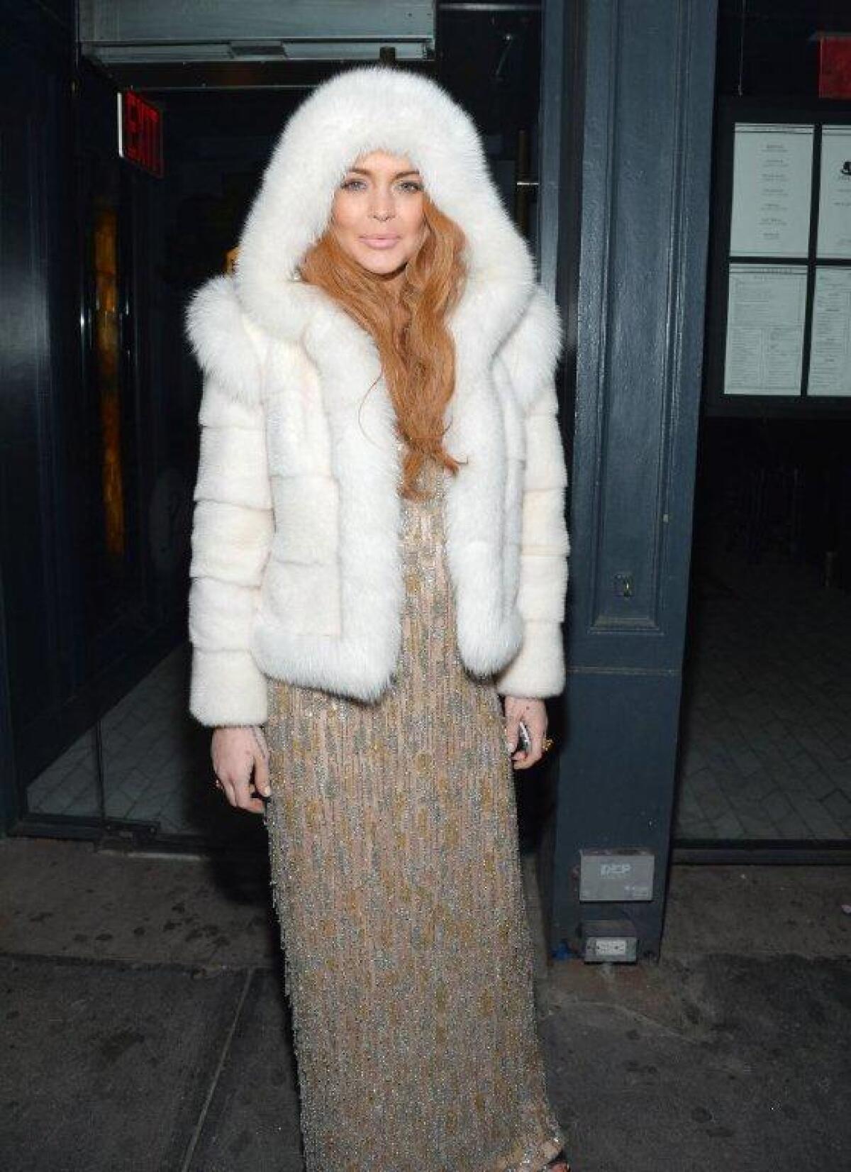 Lindsay Lohan looks ready for Winter Storm Nemo to hit as she poses in a fur hoodie at the AmFar Gala after-party in New York on Wednesday.