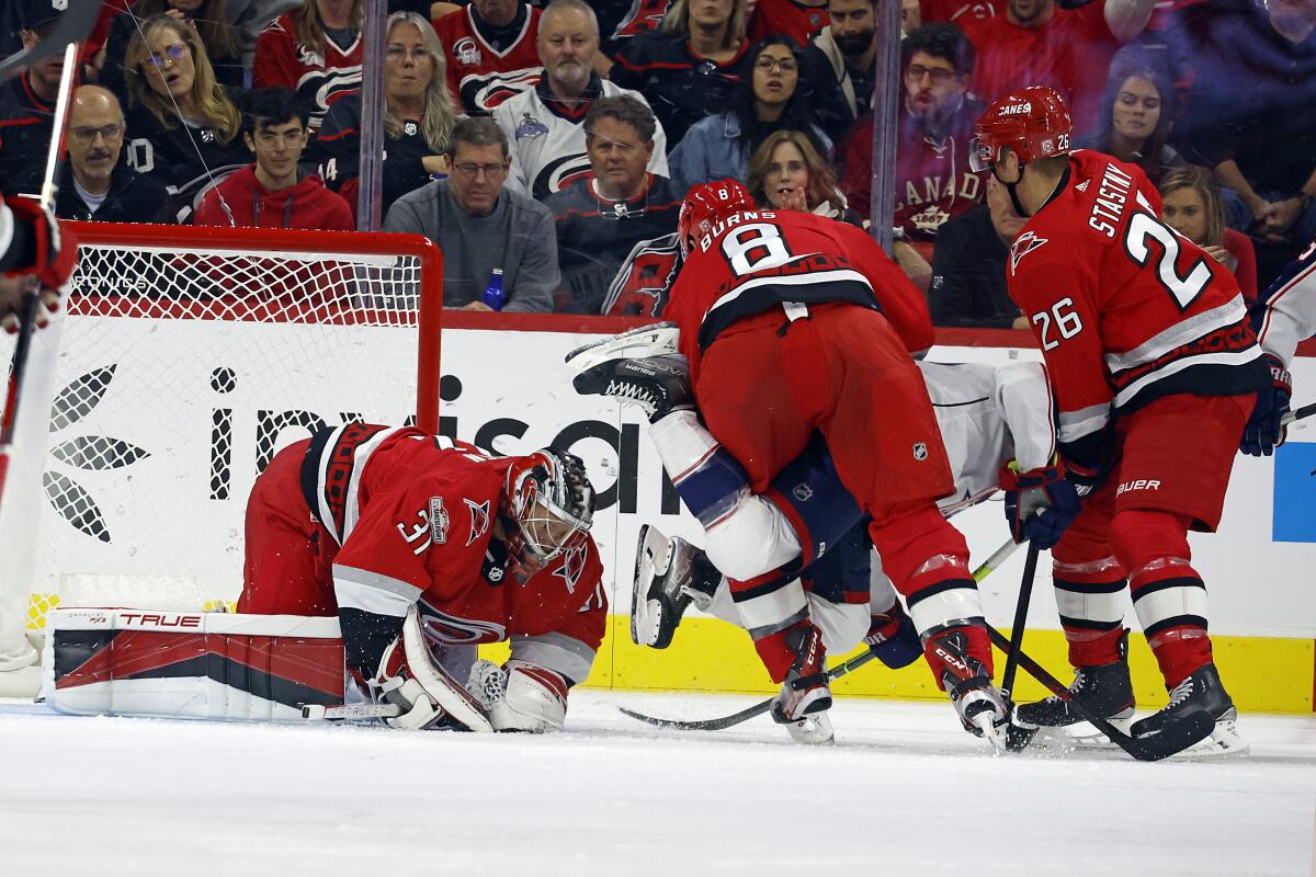 Carolina Hurricanes goaltender Frederik Andersen (31) freezes the puck as Brent Burns (8) and Paul Stastny (26) take care of Columbus Blue Jackets' Boone Jenner (38) during the second period of an NHL hockey game in Raleigh, N.C., Wednesday, Oct. 12, 2022. (AP Photo/Karl B DeBlaker)