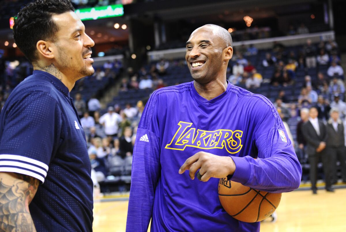 Kobe Bryant shares a laugh with ex-Lakers teammate and current Grizzlies player Matt Barnes before a game in Memphis on Wednesday.