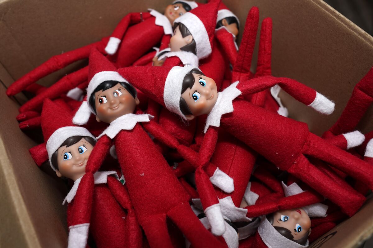 FILE - Elf on the Shelf figures are piled in a box at the company's studio Thursday, Aug. 27, 2020, in Atlanta. Santa may have fewer eyes in homes in the 2021 Christmas season after a judge — jokingly — banned the Elf on the Shelf. Superior Court Chief Judge Robert Leonard posted a mock order on Twitter banishing these elves from Cobb County, Georgia as a “gift to tired parents.” (AP Photo/John Bazemore)