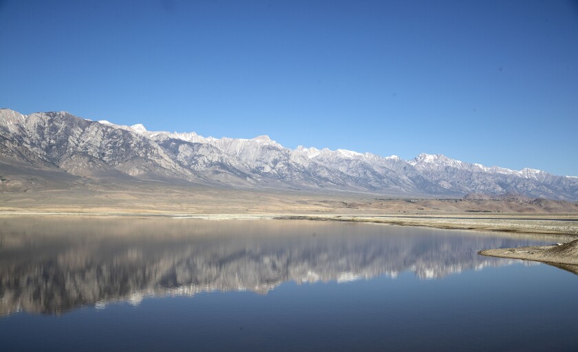 The mountains are reflected in the waters of Lake Owens.