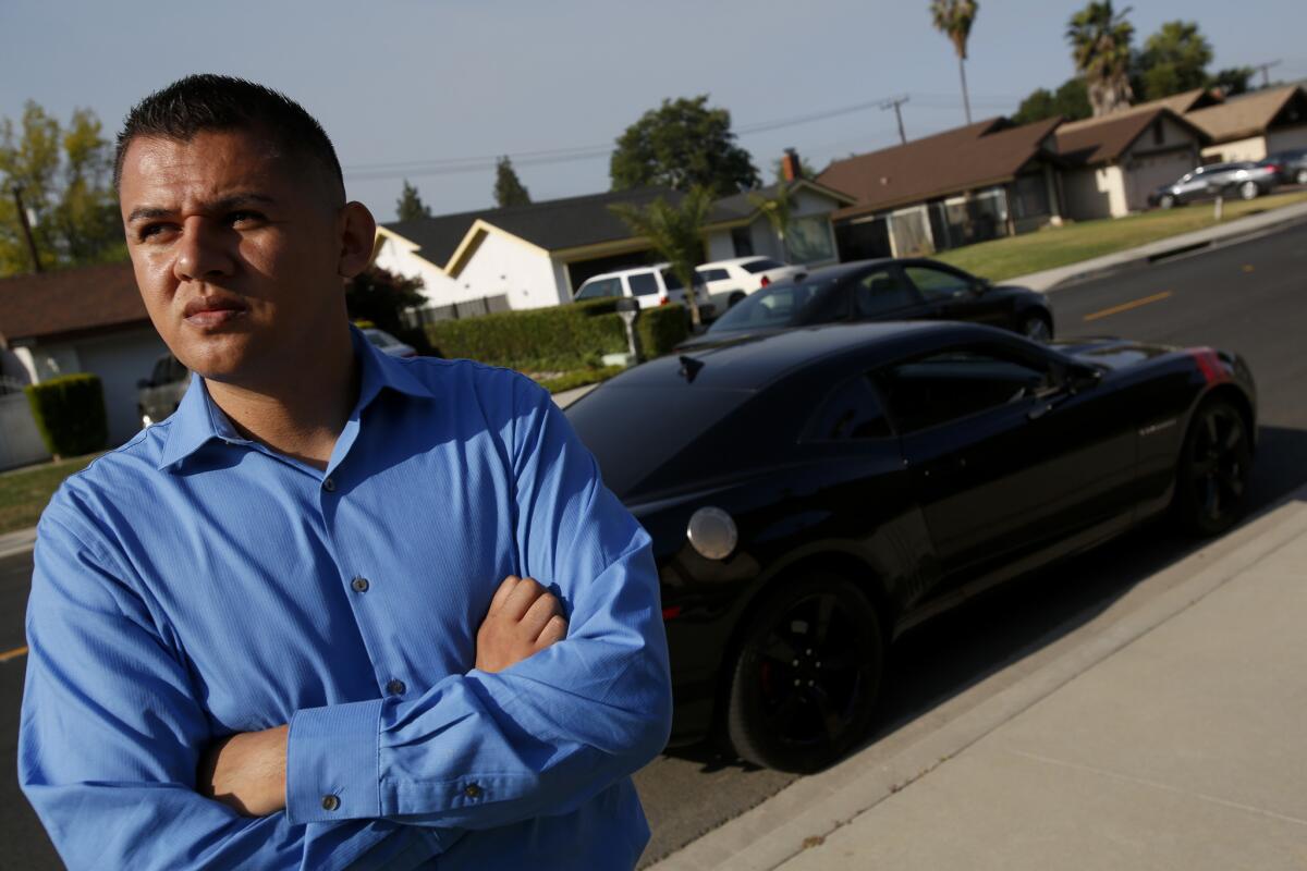 LAPD Officer Sergio Arreola poses last year for a portrait at the Pomona intersection where he was arrested by Pomona police. A jury this week awarded Arreola $260,000, finding the officers used excessive force on him and were wrong to make the arrest.