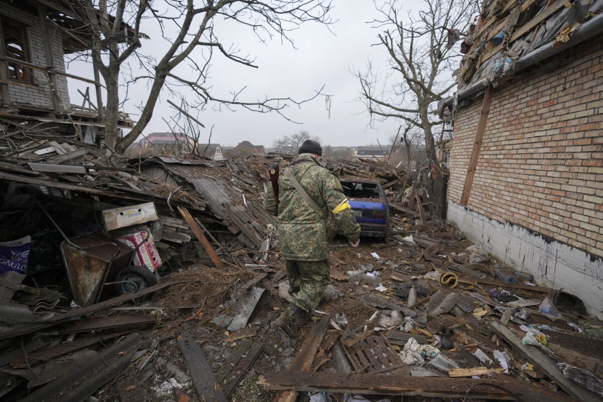 Andrey Goncharuk, 68, a member of territorial defense, walks in the backyard of a house damaged by a Russian airstrike, according to locals, in Gorenka, outside the capital Kyiv, Ukraine, Wednesday, March 2, 2022. Russia renewed its assault on Ukraine's second-largest city in a pounding that lit up the skyline with balls of fire over populated areas, even as both sides said they were ready to resume talks aimed at stopping the new devastating war in Europe.(AP Photo/Vadim Ghirda)