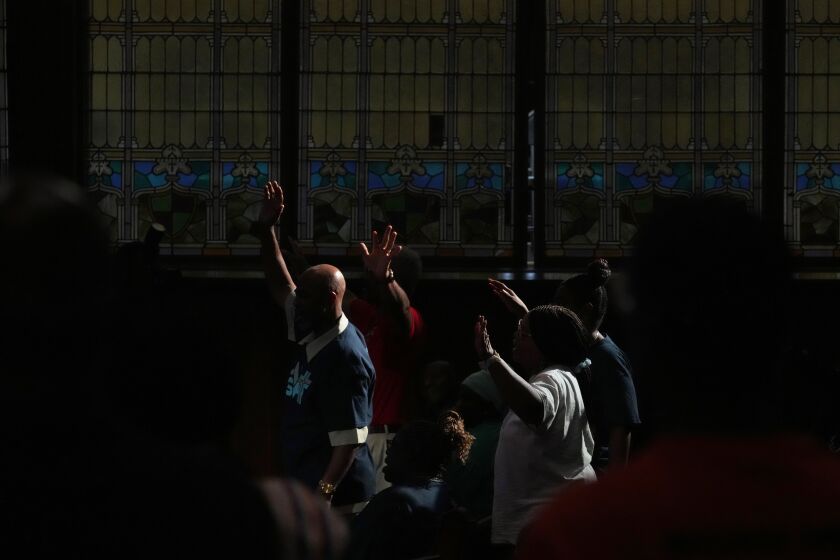 People pray during a vigil at Salt and Light church for the victims of Monday's fatal shooting spree, Wednesday, July 5, 2023, in Philadelphia. (AP Photo/Matt Slocum)