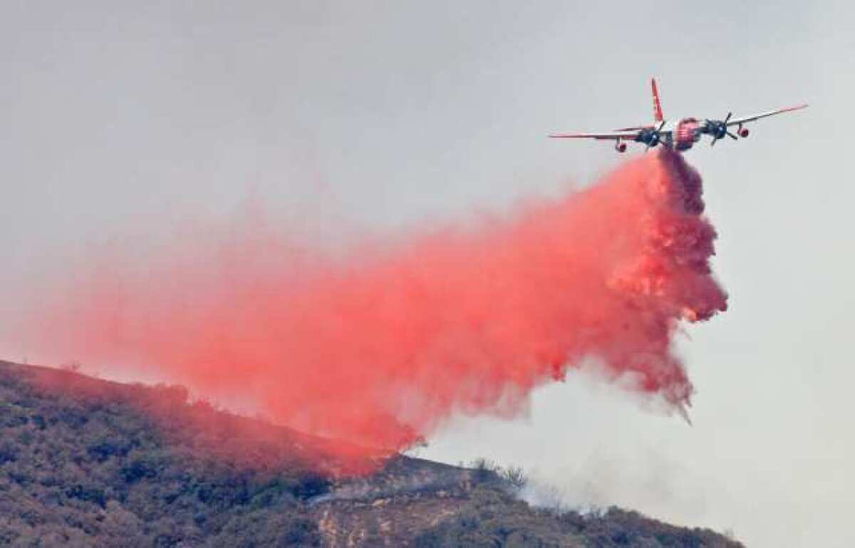An air tanker drops a load of foscheck fire retardant on a brush fire in Angeles National Forest above La Canada in 2009.
