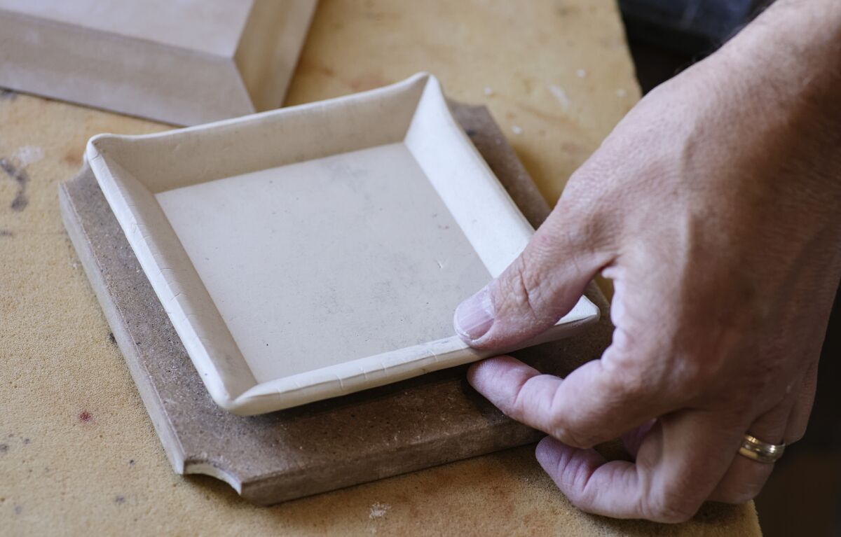 Bounaud shapes rolled-out clay into one of his food-grade small plate ceramic pieces.