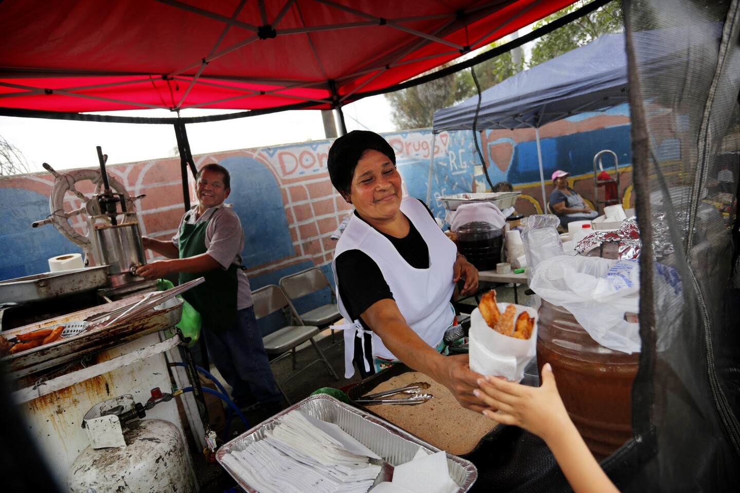 Vendors make churros to be sold for one dollar on Saturday at Ramona Gardens.