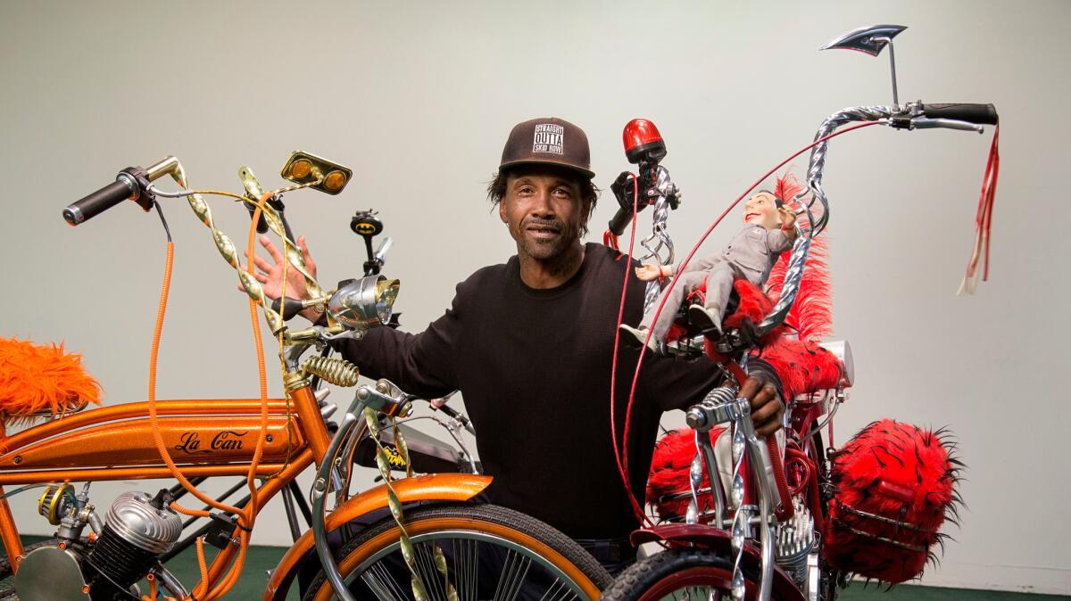 Skid Row artist and activist General Dogon posing with his custom bikes at the Los Angeles Poverty Department's Skid Row History Museum and Archive.