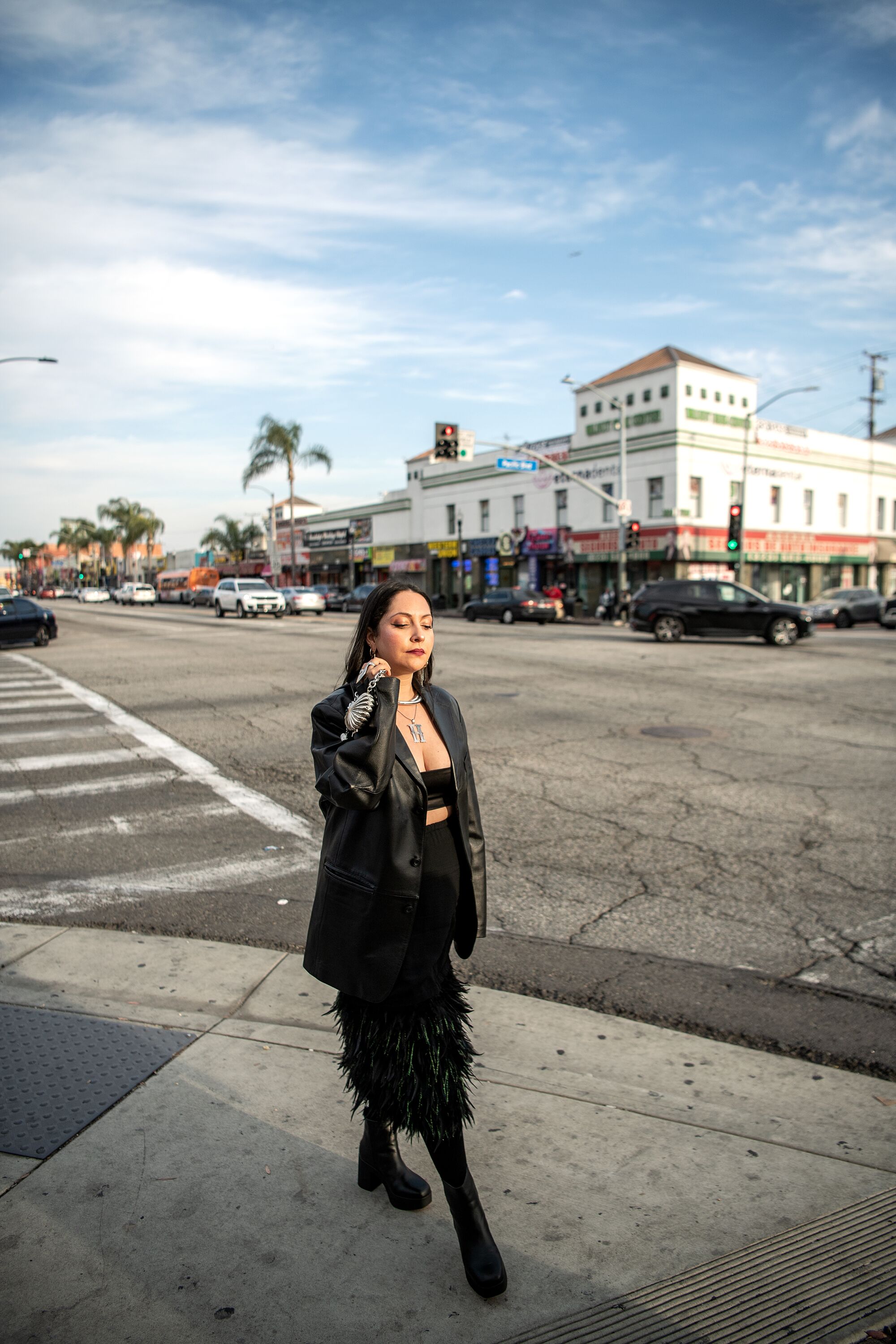 A woman stands at the corner of Florence Avenue and Pacific Boulevard.