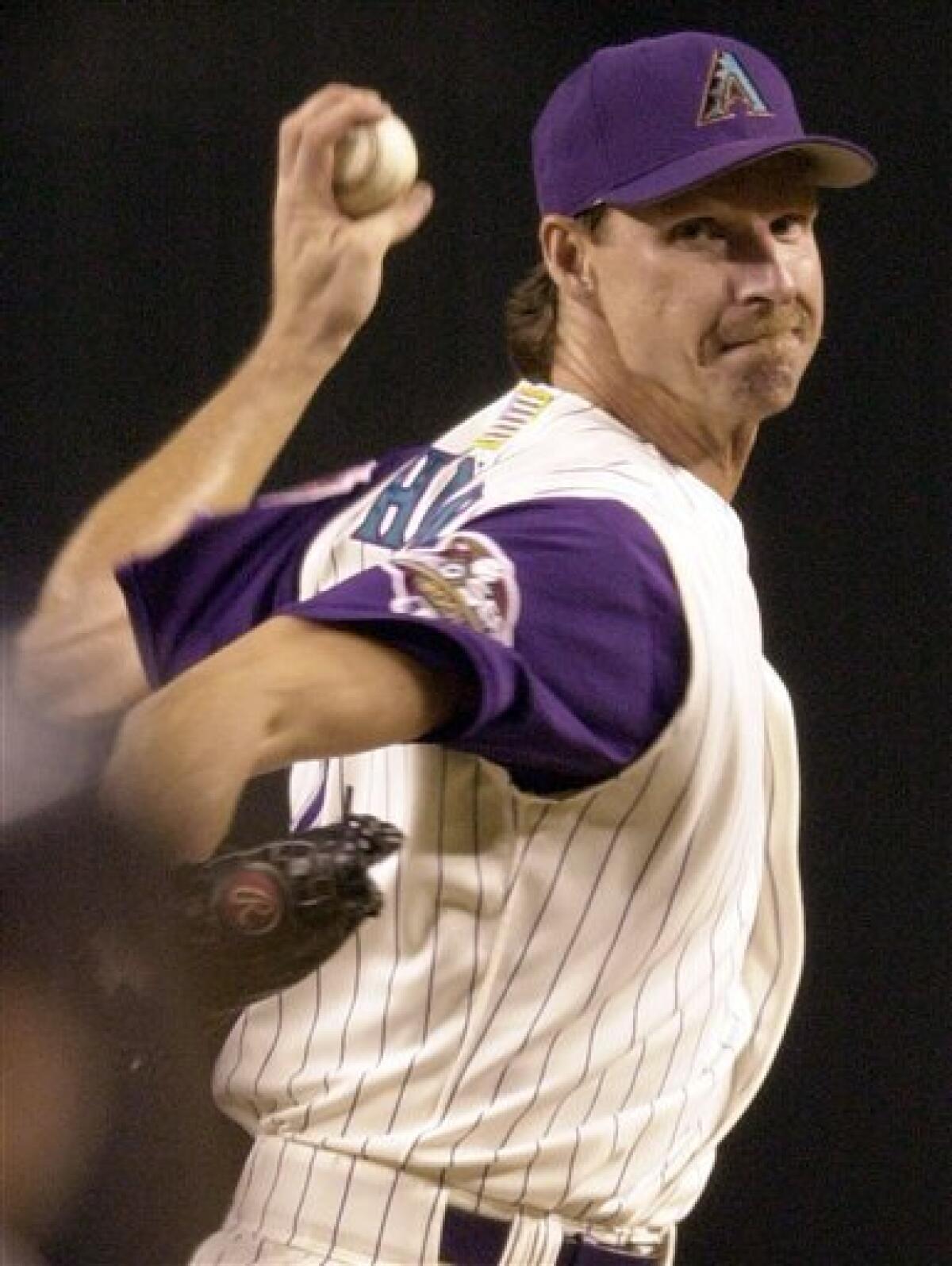 FILE - In this Nov. 3, 2001, file photo, Arizona Diamondbacks pitcher Randy Johnson throws against the New York Yankees in the first inning of Game 6 of baseball's World Series at Bank One Ballpark in Phoenix. Johnson is retiring after 22 major league seasons. The Big Unit, an overpowering lefty who last June became the 24th pitcher in big league history to win 300 games, made the expected announcement on a conference call on Tuesday, Jan. 5, 2010. (AP Photo/Matt York, File)