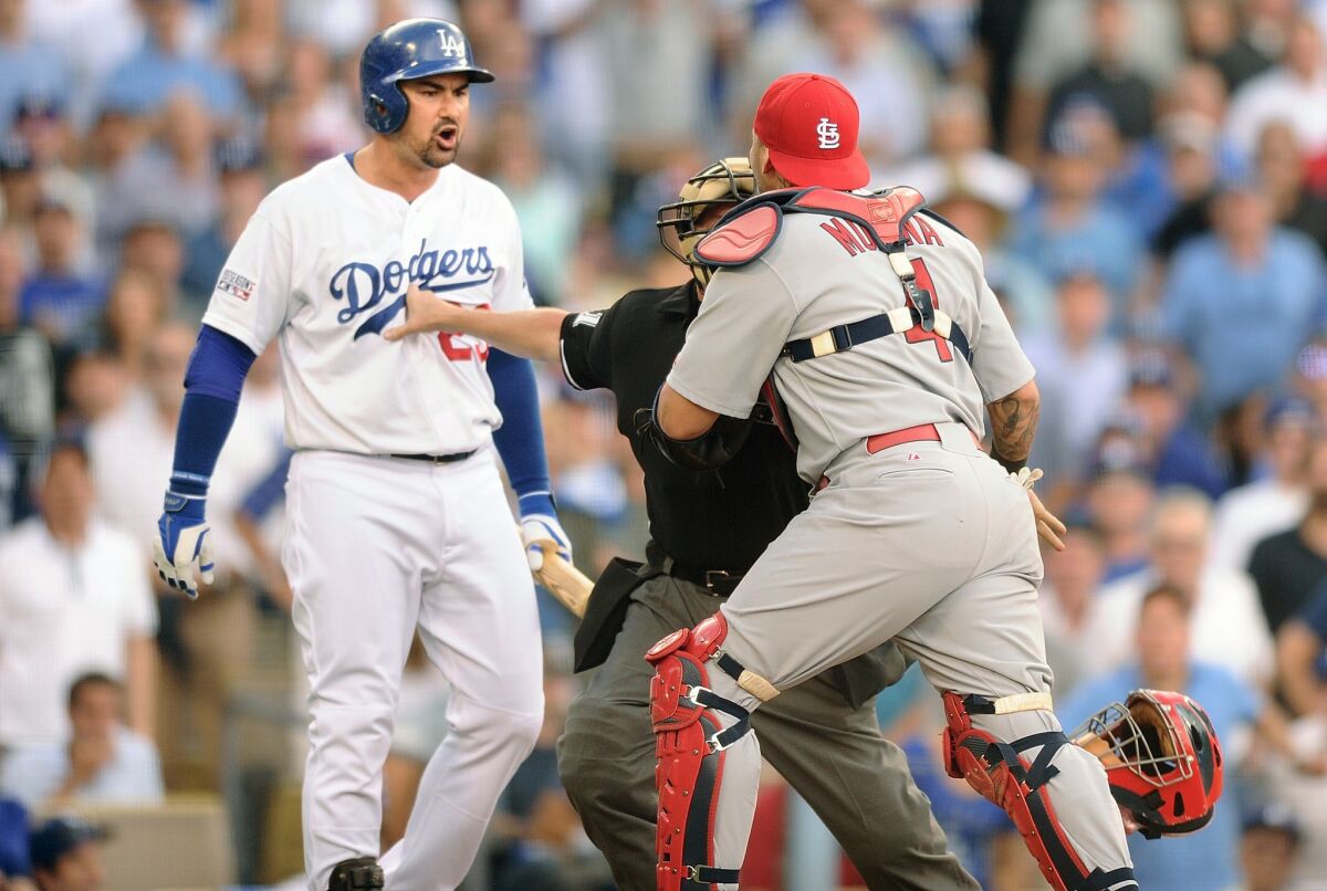 Dodgers first baseman Adrian Gonzalez has some words for Cardinals catcher Yadier Molina shortly after teammate Yasiel Puig was hit by a pitch in the third inning.