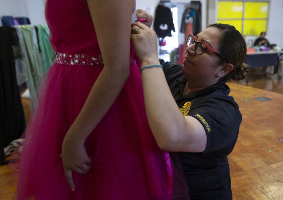 Aurora, 16, tries on prom dresses with help from probation officer Janet Ramos.