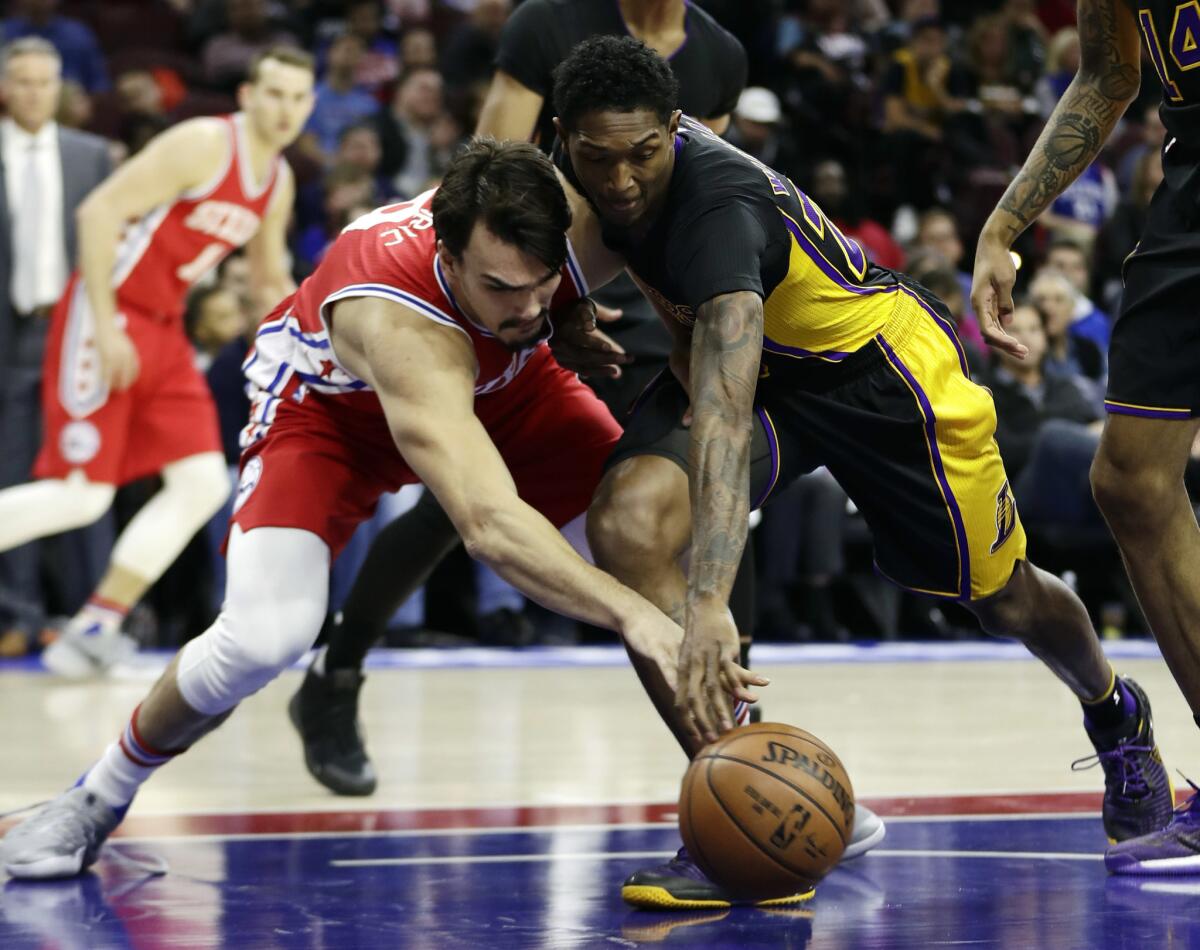 Philadelphia 76ers forward Dario Saric, left, and Lakers guard Louis Williams pursue a loose ball during the first half on Dec. 16.
