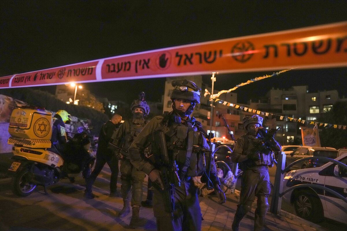 Israeli forces secure the area of a stabbing attack in the town of Elad, Israel, Thursday, May 5, 2022. Israeli medics say at least three people were killed in a stabbing attack near Tel Aviv on Thursday night. Israeli police said they suspect it was a militant attack. (AP Photo/Maya Alleruzzo)