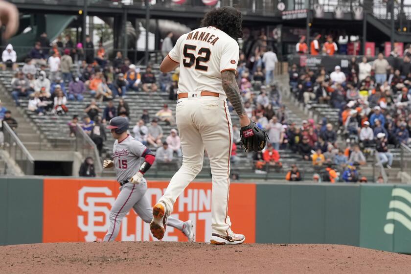 San Francisco Giants pitcher Sean Manaea walks back to the mound as Washington Nationals' Riley Adams, left, rounds the bases after hitting a three-run home during the second inning of a baseball game in San Francisco, Wednesday, May 10, 2023. (AP Photo/Tony Avelar)