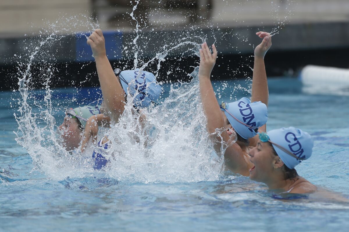 Members of the Corona del Mar girls' swim team cheer on their teammates during Tuesday's meet.