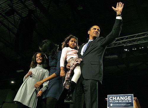 Democratic presidential candidate Barack Obama waves to a crowd of supporters with his family while celebrating his victory in the Iowa caucus at Hy-Vee Hall in Des Moines.