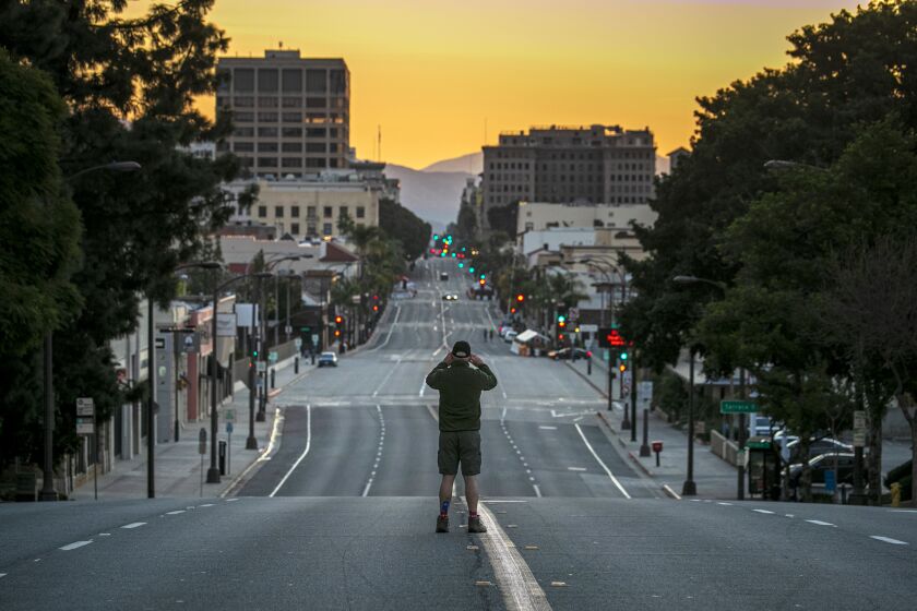 Pasadena, CA - January 01: First time since 1945, the Rose Parade in Pasadena has been cancelled due to COVID-19 pandemic. Jim Safford stops by to take a photo of deserted Colorado Blvd. on Friday, Jan. 1, 2021 in Pasadena, CA. (Irfan Khan / Los Angeles Times)