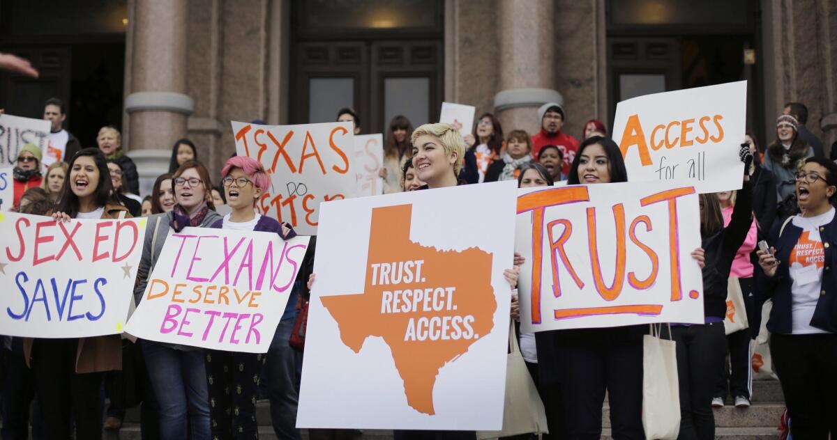 College students and abortion rights activists hold signs during a rally on the steps of the Texas Capitol in Austin on Feb. 26.
