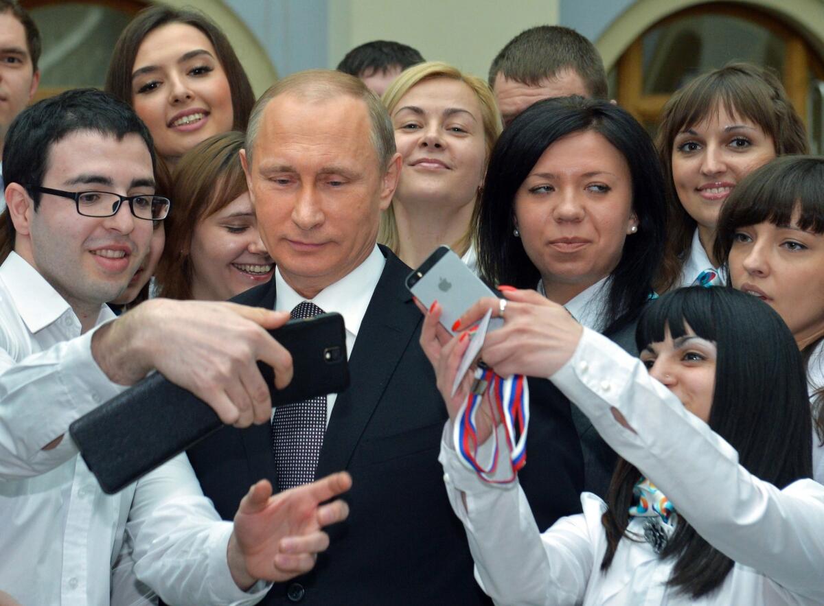 Russian President Vladimir Putin poses for photos with call center operators after his nearly four-hour exchange with Russians on live television Thursday.