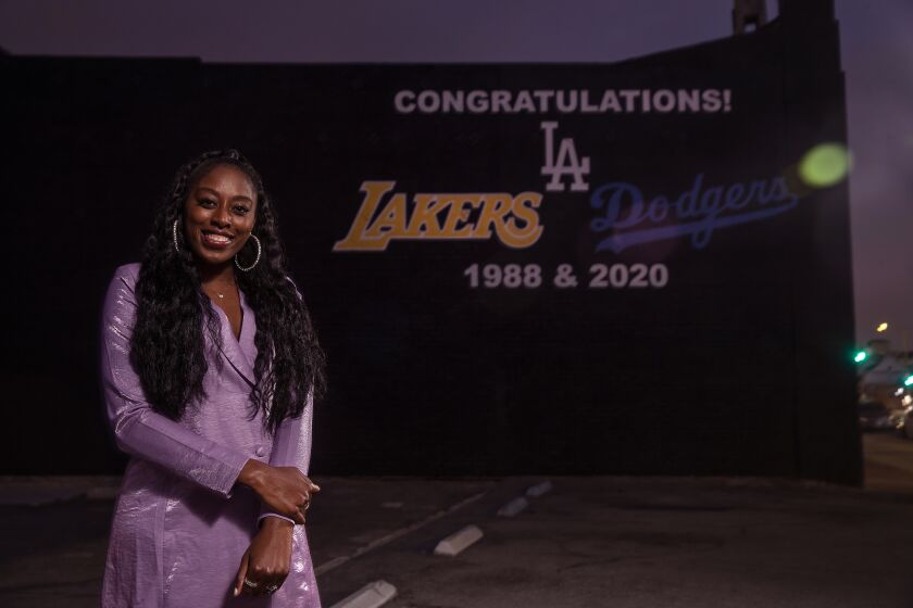 LOS ANGELES, CA - DECEMBER 10: Chiney Ogwumike, of the Los Angeles Sparks, is photographed in front of a mural on 3rd St. in Los Angeles, honoring the Los Angeles Lakers and Los Angeles Dodgers on their 1988 and 2020 championship seasons. Ogwumike opted out of playing in the WNBA this season due to medical reasons. (Mel Melcon / Los Angeles Times)