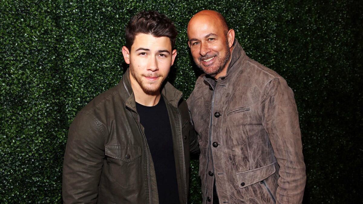 Singer Nick Jonas, left, and fashion designer John Varvatos during a personal appearance at Bloomingdale's at Westfield Century City in Los Angeles.