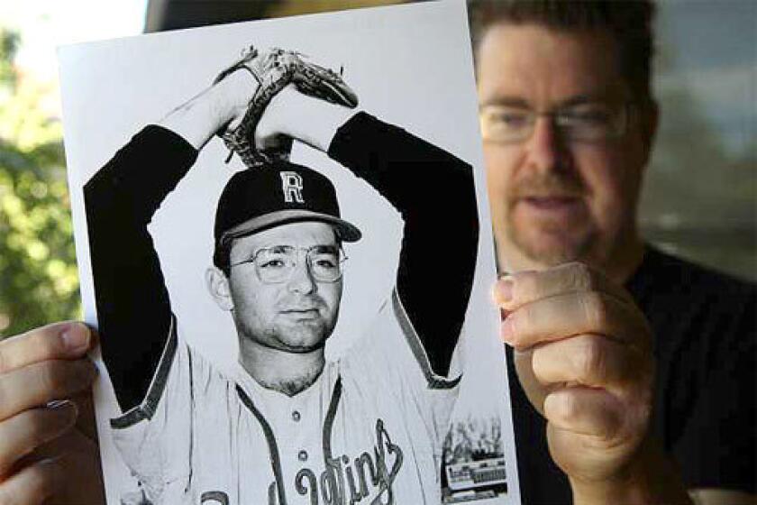 Baseball historian Terry Cannon holds a photo of Steve Dalkowski, a minor leaguer who is believed by some to have thrown the fastest pitch in history.