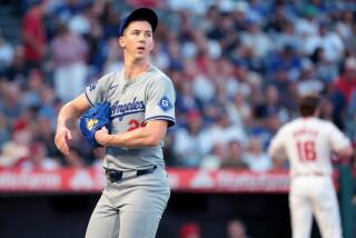 Dodgers pitcher Walker Buehler looks across the field as he walks off the mound during a game against the Angels