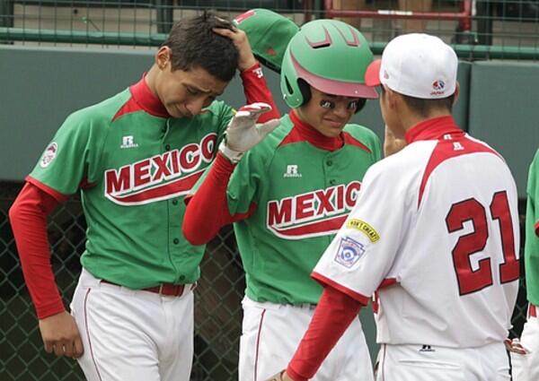 Japan, pitcher Yoshiki Suzuki shakes hands with Mexico's Carlos Arellano, center, and Alonso Garcia, left, after the International championship game.