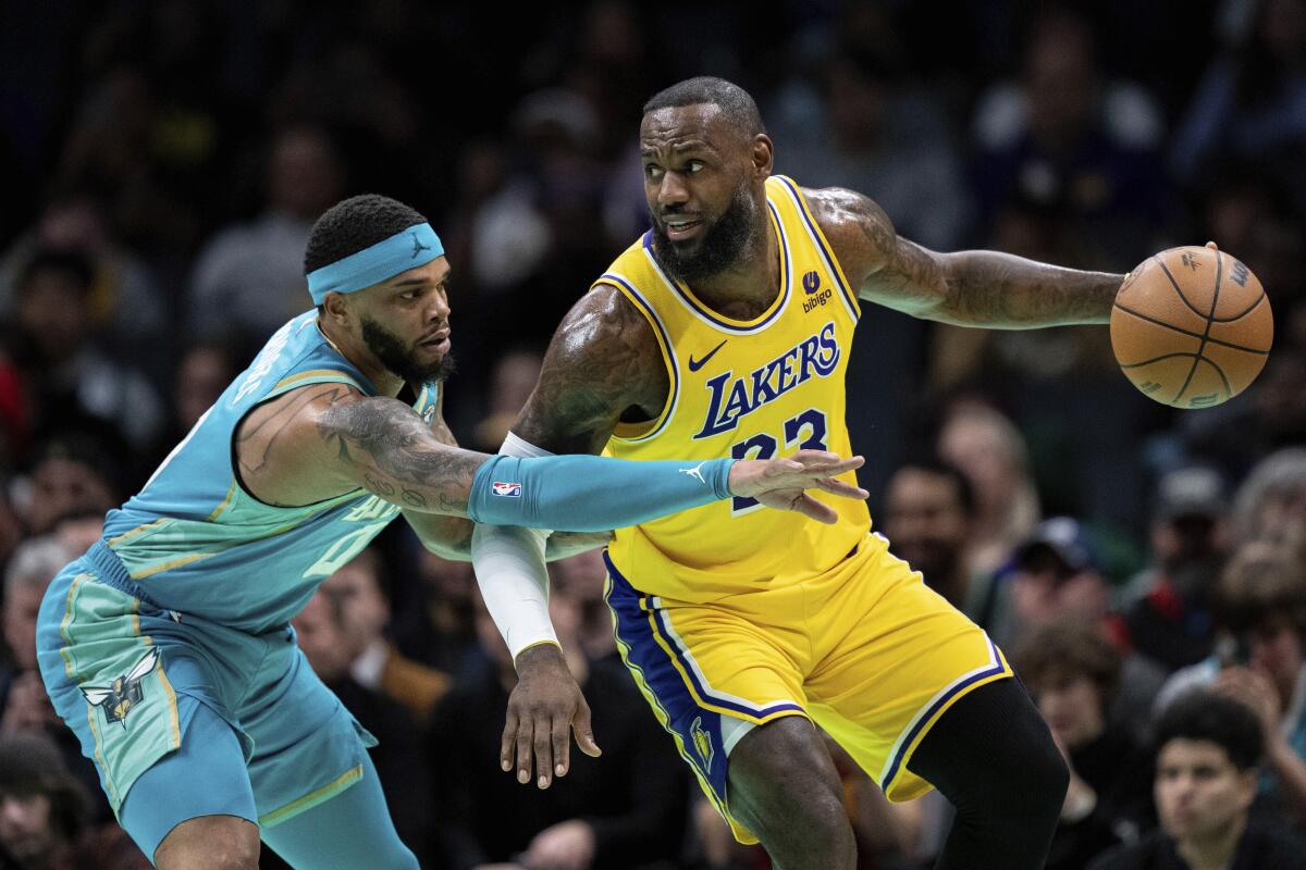 Lakers forward LeBron James, right, looks to drive the baseline against Hornets forward Miles Bridges.